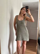 Vestido corto de tejido de punto, color marrón con hilos dorados (lurex) que le dan un brillo sutil. Diseño de tirantes anchos y escote redondo.