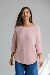 Sweater de punto color rosa pastel, con escote redondo a la base y mangas tres cuartos con dobladillo en los puños. Presenta un corte holgado y ruedo redondeado.