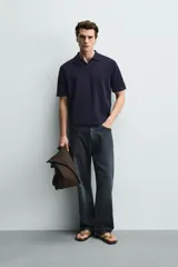 Polo de punto azul marino, de corte regular fit, con cuello solapa, abertura frontal en V y mangas cortas.