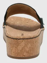 Sandalia tipo slide de Hush Puppies con capellada de cuero negro y banda elástica lateral. Presenta una suela de plataforma alta con acabado de corcho y base de caucho.