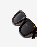 Gafas de sol Hawkers modelo Uptown, unisex, con montura cuadrada de carey marrón y lentes degradadas en gris.