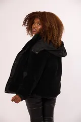 Campera reversible para mujer con diseño acolchado de nylon en un lado y corderito sintético en el otro. Cuenta con capucha, cierre frontal y mangas largas.