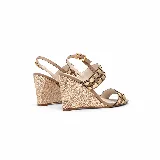Sandalias de cuero color tostado con taco chino forrado en yute, pulsera regulable al tobillo y tiras delanteras decoradas con tachas y detalles metalizados dorados.