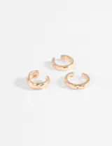 Set de tres earcuffs de metal plateado con diferentes texturas irregulares, diseñados para colocarse en el cartílago de la oreja sin necesidad de perforación.