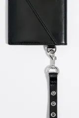 Billetera tipo sobre de Bimba y Lola, color blanco, con cierre de solapa y snap. Incluye un asa de mano extraíble con ojetes metálicos y logo estampado en el frente.