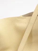 Cartera bandolera de cuero floater color negro, de diseño cilíndrico tipo bucket, con correa larga para llevar al hombro o cruzada y broche de imán.