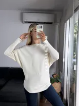 Sweater color marrón de manga murciélago oversize, con escote barco y bordado de lentejuelas y canutillos al tono en hombros y mangas.