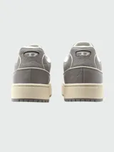 Zapatillas Diesel modelo S-Tracker-D, estilo retro de caña baja, color gris con cordones blancos y suela gruesa color crema. Presentan texturas en el material exterior y el logo de la marca en el lateral.