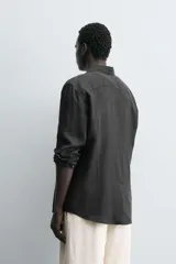 Camisa de corte regular fit confeccionada en tejido de lino, con cuello solapa, manga larga con puños abotonados y cierre frontal de botones.