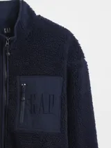 Canguro de polar negro con cierre frontal, cuello alto y bolsillo en el pecho con cierre y logo de la marca bordado.