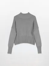 Polera gris de tejido de punto, con cuello alto, hombros caídos y mangas largas. Puños y cintura en rib.