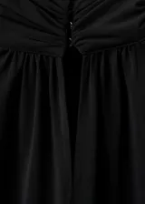 Blusa negra de cuello alto con cierre de botones, diseño recto y mangas largas acampanadas con volantes en los puños. Confeccionada en tejido fluido.