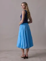 Falda midi color amarillo pálido, de algodón, con pretina ancha elastizada y forro interno a tono.