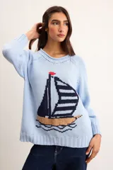 Sweater de punto color marfil con diseño de velero en la parte frontal, cuello con capucha y cordón rojo de ajuste.