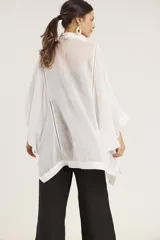 Camisa de manga ancha, color verde salvia, con cuello camisero y cierre frontal de botones. Presenta detalles de pespunte decorativo en el canesú frontal.