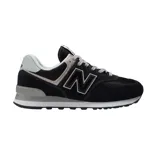 Championes urbanos New Balance modelo 574, color negro con detalles en gris y blanco. Confeccionados en una combinación de gamuza y malla, presentan el logo 'N' característico en los laterales y entresuela con tecnología ENCAP para mayor amortiguación.