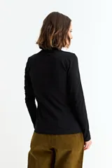 Remera básica de manga larga con cuello polera, confeccionada en tejido suave y elástico.