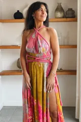 Vestido largo de seda con estampado abstracto en tonos marrones, beige y destellos dorados, con escote en V profundo, tirantes de cuerda anudados al cuello y la cintura, y tajo lateral en la falda.