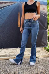 Pantalón de jean azul de tiro alto, corte semi oxford con botamanga ancha y abierta, y ruedo al corte.