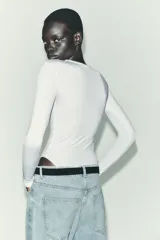 Body de manga larga confeccionado en mezcla de poliamida, con cuello redondo y cierre inferior con botones a presión.