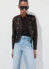 Pantalón de jean de tiro medio y diseño wide leg con bolsillos de solapa delanteros, trabillas para cinto y cierre con gancho y cremallera.