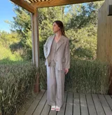 Blazer azul marino con rayas verticales blancas, confeccionado en lino italiano. Tiene botones de coco, solapas clásicas y bolsillos delanteros.