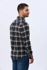 Camisa de viyela a cuadros en tonos marrón, azul marino y gris, con cuello clásico, cierre frontal con botones, mangas largas y un bolsillo en el pecho.