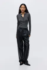 Top de manga larga en tejido de punto acanalado, de corte ajustado, con cuello elevado y tapeta de botones frontal, presentando un diseño con forro interior en contraste.