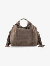 Cartera de mano confeccionada en cuero gamuzado color marrón, con diseño flexible y detalles de flecos laterales. Presenta un asa rígida metálica circular y una abertura superior fruncida.