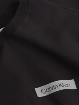 Remera de manga larga negra de algodón regenerado, con cuello redondo y logo de Calvin Klein estampado en el pecho.