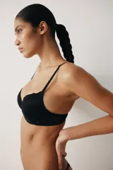 Soutien push-up negro de encaje con aros y copas acolchadas, breteles ajustables y cierre de corchetes en la espalda.