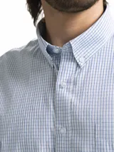 Camisa de hombre de manga corta con estampado a cuadros en tonos blanco, verde y marrón. Tiene cuello abotonado y bolsillo en el pecho.