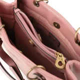 Cartera tipo tote bag color rosa, con diseño acolchado en forma de chevron. Tiene doble asa corta, correa larga regulable y herrajes dorados. El acceso es con cierre y broches imantados. Cuenta con tres compartimentos y bolsillos internos.