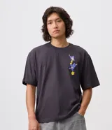 Remera boxy de algodón gris oscuro, con cuello redondo, mangas cortas y estampa localizada en el pecho con personajes de Los Cariñositos y Hello Kitty interactuando con estrellas.