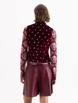 Chaleco de velvet color bordó con estampado floral, cuello mao y terminaciones con vivo en contratono. El acceso es mediante cruce diagonal con broches dorados. Tiene pinzas delanteras y traseras que le dan un fit al cuerpo y un sutil efecto evasé en la parte inferior.