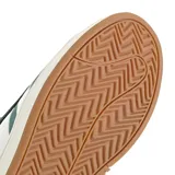 Championes urbanos Adidas modelo Grand Court Alpha, color verde azulado con las icónicas tres tiras laterales en blanco. Presentan una capellada de material sintético con efecto gamuzado, lengüeta acolchada con logo de la marca y suela de goma en tono crema con base color caramelo.