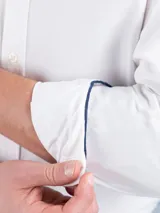 Camisa blanca de corte regular fit, cuello button-down, manga larga con puño simple y logo bordado en el pecho. Confeccionada en tejido oxford compuesto por 93% algodón y 7% algodón reciclado.