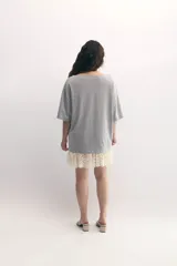 Remerón gris de cuello bote, con bordado del monograma de la marca a tono y encaje blanco integrado en el ruedo. Confeccionado en malla fina compactada de algodón.