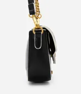 Bolso negro tipo baguette con correa de cadena dorada y correa corta blanca. Tiene cierre de tapa con broche dorado con el logo STN.