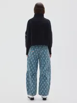 Polera de punto color negro con cuello alto, hombros caídos y mangas largas. Presenta puños, cuello y ruedo acanalados en tejido rib ancho.