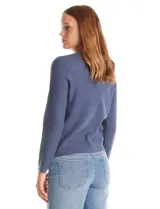 Cardigan de punto color fucsia, con escote a la base, cierre frontal con botones metálicos dorados y terminaciones desflecadas. Presenta bolsillos simulados en la parte delantera y mangas largas.