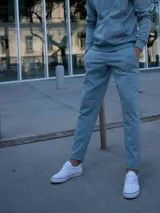 Pantalón de felpa color celeste/azul claro, de corte slim y tiro medio, con puños ajustados en los tobillos.