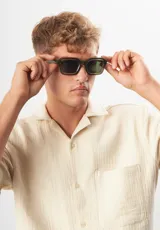 Lentes de sol Eco Shades modelo Romano, con montura cuadrada color verde oliva y lentes verdes. Fabricados con acetato biodegradable y lentes de PMMA reciclado. Cuentan con protección UV 400.