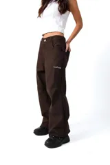 Pantalón de gabardina color marrón oscuro, corte ancho y holgado, con bordado en el frente y la espalda.