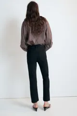 Jeans de tiro alto con cinco bolsillos, diseño cropped flare y bajo sin costuras. Cuenta con cierre frontal de cremallera y botón metálico.