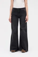 Jean de corte wide leg en color negro lavado, con tiro medio, ajuste en cintura y cadera, y ruedo deshilachado.