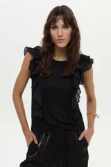 Blusa blanca vaporosa con volados en los hombros y cuello redondo.