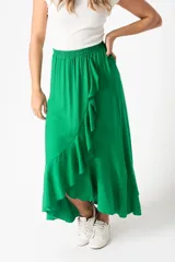 Pollera larga color verde esmeralda, de corte evasé, con cintura elastizada y volantes diagonales en el frente.