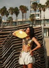 Traje de baño tipo cut-out con diseño geométrico en tonos marrón, amarillo y blanco, con detalles de textura tipo cuadrillé y cierre frontal.