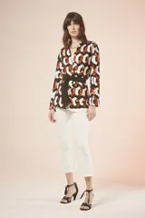 Saco con estampado geométrico en tonos blanco, negro y naranja, con cuello en V, mangas largas y lazo negro para ajustar en la cintura.